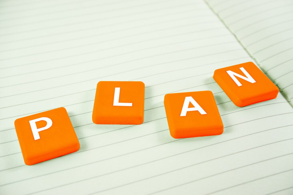 Scrabble tiles on a notebook spelling the word plan